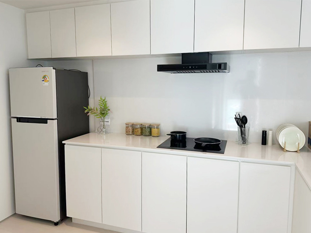 Project case image for an apartment project in Thailand. The close-up view highlights a section of the L-shaped kitchen, showcasing sleek cabinetry, a modern countertop, and integrated appliances. The design emphasizes clean lines, high-quality materials, and a functional, contemporary aesthetic.