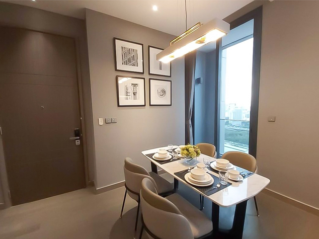 Project case image for The Esse Singha Complex apartment project in Thailand. The image showcases a modern dining area with elegant furniture, contemporary lighting, and a refined color palette. The space is designed to offer a sophisticated yet inviting atmosphere, perfect for both everyday meals and entertaining guests.