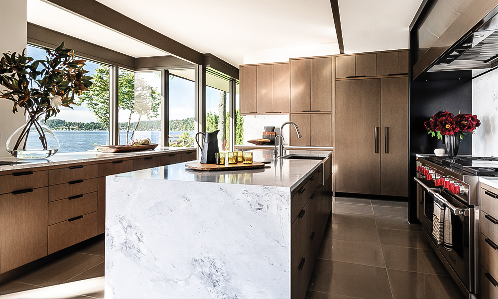 A modern L-shaped kitchen featuring wood veneer cabinets and a central countertop island. The natural wood texture adds warmth and sophistication, while the L-shaped layout maximizes functionality and storage. The central island serves as a practical workspace and a stylish centerpiece, enhancing the contemporary design of the kitchen.
