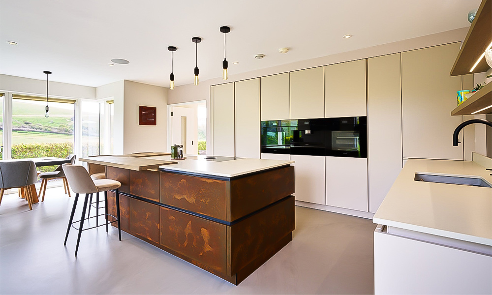 An L-shaped kitchen featuring light lacquered cabinetry, paired with a central island that adds both style and practicality. The soft, light tones of the cabinets create a bright and airy atmosphere, making the space feel open and welcoming. The central island enhances the kitchen's functionality, providing additional counter space and storage. The clean lines and modern finish of the cabinetry complement the minimalist design, while the island serves as a focal point for both cooking and socializing in this contemporary kitchen setting.
