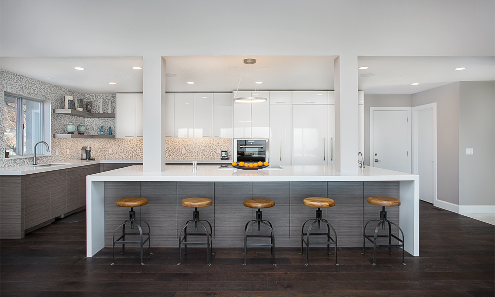 A close-up view of an L-shaped kitchen featuring dark wood veneer base cabinets, sleek white lacquered upper cabinets, and a central island. The contrast between the dark wood and bright white elements creates a modern and elegant look, highlighting the rich textures and refined details in this contemporary kitchen space.