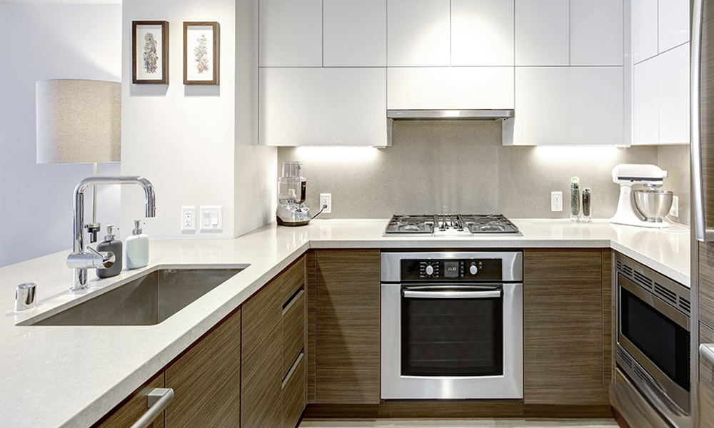 Close-up of a modern U-shaped kitchen with wood veneer base cabinets, white lacquered upper cabinets, and a marble central island, highlighting the elegant blend of natural textures and contemporary design.