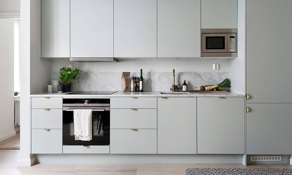 A one-wall kitchen with gray cabinetry, creating a sleek and contemporary look. The soft gray tones add a sense of calm and sophistication, enhancing the modern design of the space.