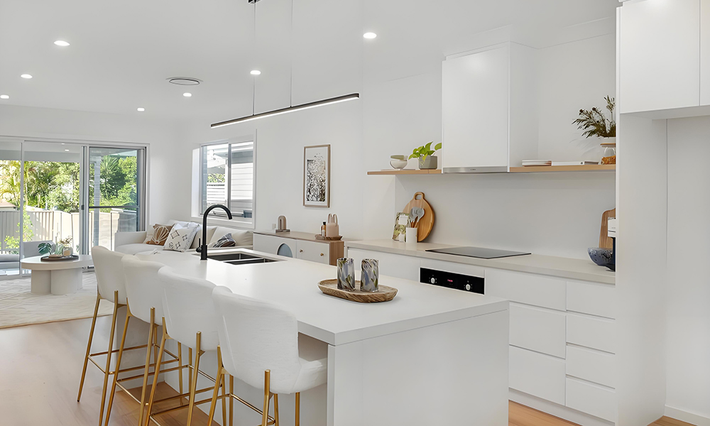 A bright one-wall kitchen with white cabinetry and a central island. The minimalist white design creates a clean and airy atmosphere, while the island offers extra workspace and serves as a modern focal point in the kitchen.