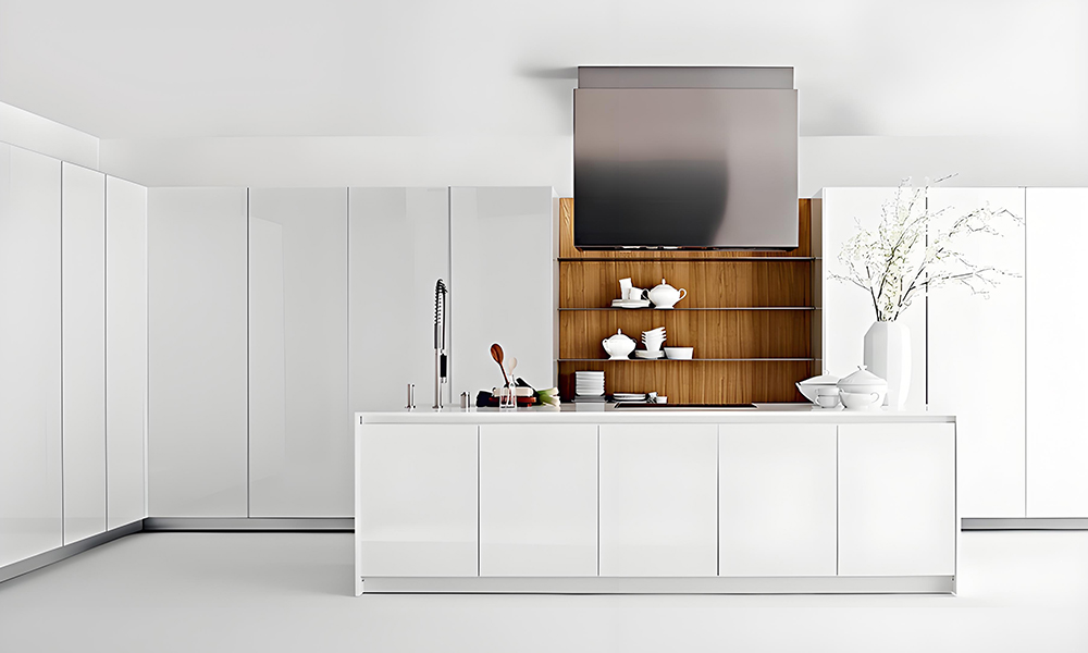 A modern kitchen featuring white cabinetry and a white central island. The sleek, all-white design creates a bright, clean, and minimalist aesthetic, with the island adding both functionality and a cohesive focal point to the space.