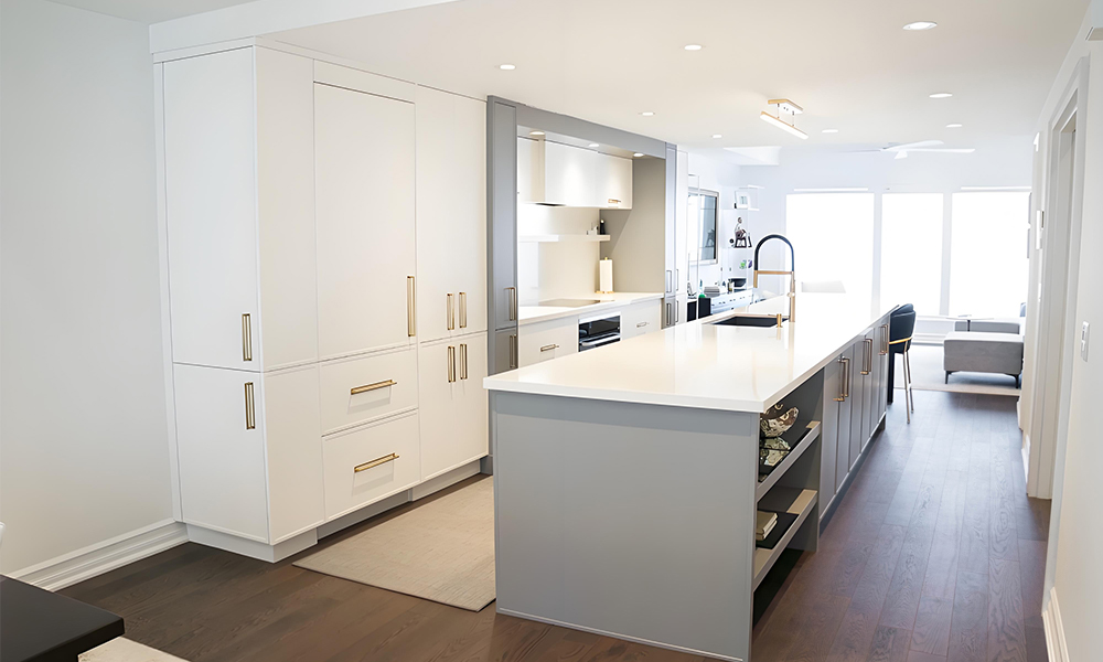 A close-up view of a kitchen featuring glossy lacquered cabinetry and a white central island. The polished, reflective surface of the cabinets enhances the modern, sleek look, while the white island serves as a bright, functional centerpiece in the stylish layout.