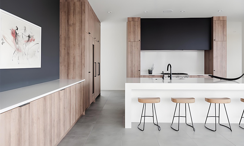 A close-up view of a kitchen featuring wood veneer cabinets and a white central island. The warm, natural wood tones of the cabinets contrast beautifully with the bright, clean white of the island, creating a harmonious balance of elegance and functionality in the space.