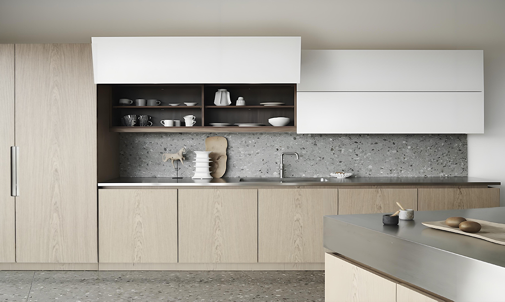 A close-up view of a one-wall kitchen featuring light wood veneer cabinets. The soft, natural wood tones create a warm, inviting atmosphere, highlighting the sleek design of the cabinetry in this modern, minimalist kitchen layout.