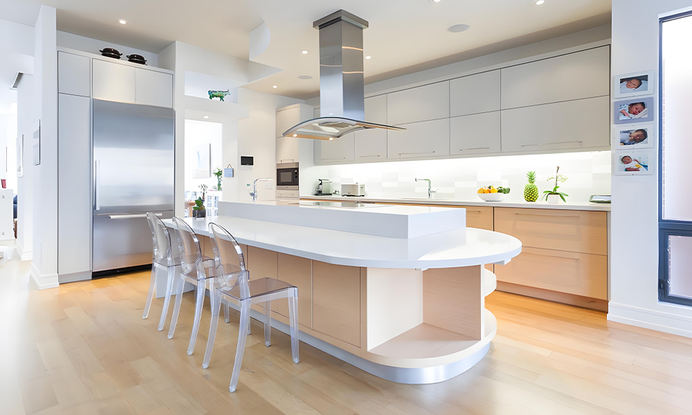 A modern kitchen featuring white cabinetry and a central island. The sleek, minimalist design emphasizes the bright, clean look of the white cabinets, while the island adds both functionality and a stylish focal point to the space.