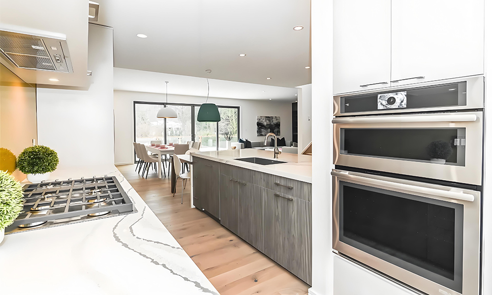 A close-up view of a kitchen featuring white cabinetry and a matching white island. The clean lines and smooth white finishes create a minimalist and modern design, highlighting the bright, spacious atmosphere of the kitchen."