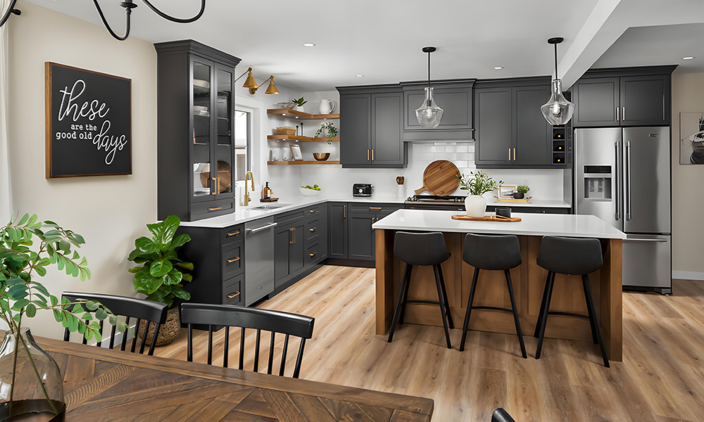 A modern L-shaped kitchen featuring black cabinetry and a wood-finished central island. The sleek black cabinets create a bold, sophisticated atmosphere, while the natural wood island adds warmth and organic texture. The L-shaped layout enhances functionality and provides ample workspace, and the central island serves as a stylish focal point for food preparation, casual dining, or socializing. The overall design balances contemporary elegance with cozy charm.
