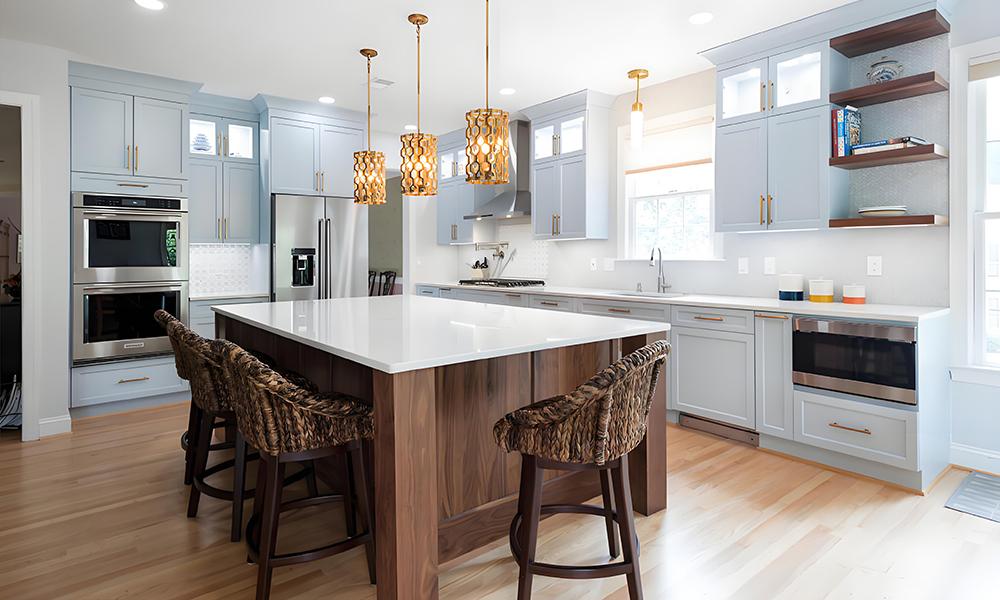 A modern L-shaped kitchen with white cabinetry and a wood veneer central island. The contrast between the sleek white cabinets and the warm wood island creates a balanced and inviting atmosphere. The layout offers ample storage and workspace, with the central island serving as both a functional cooking area and a stylish focal point. This design blends contemporary and natural elements, providing a welcoming and stylish environment for cooking and entertaining.