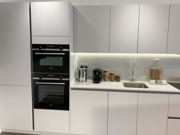 Project case image for Lace Market Point, located in the UK. The image showcases elegant cabinetry, featuring sleek white lacquered finishes. The cabinets are designed with modern functionality in mind, offering ample storage space and a minimalist aesthetic, enhancing the contemporary appeal of the kitchen or living area.