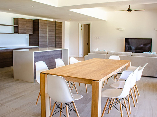 Project case image for Manta Cove by Horizon Holidays, located in Mauritius. The image highlights a stylish dining area featuring a modern dining table paired with elegant cabinetry. The sleek, contemporary design of the furniture and cabinetry enhances the sophisticated atmosphere of the space, offering a perfect setting for dining and relaxation.