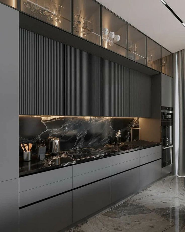 Luxury kitchen setup with custom black kitchen cabinets combined with stainless steel appliances, pendant lights, and a waterfall island.